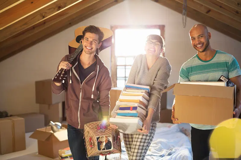 Young people with boxes in an attic